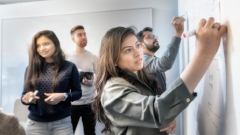 Students writing on a whiteboard