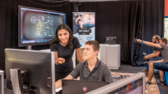 Two students looking at a computer screen as they discuss what is on there