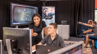 Two SRH International Pre-Masters computing students working together at a computer screen.
