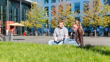 Two students enjoy a cup of coffee in the main campus at SRH Heidelberg.